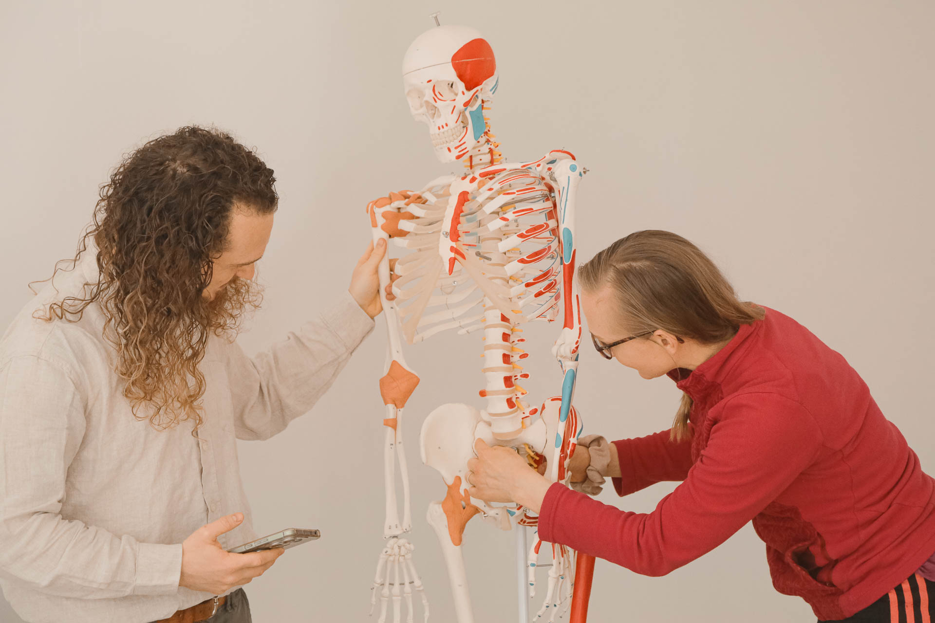 Adrien, ostéopathe, explique à une élève l’anatomie du squelette humain grandeur nature durant la formation Yoga 200h à l’Académie Yoga Paris – Sagesse & Harmonie, dans le 15ᵉ arrondissement de Paris.