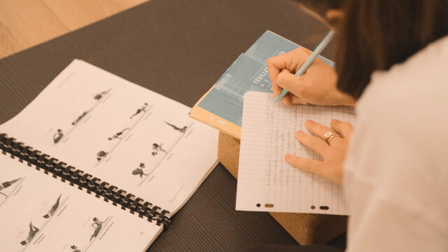 Élève concentrée en train d’écrire pendant la formation 200h Hatha Yoga au studio du XVe arrondissement de Paris.